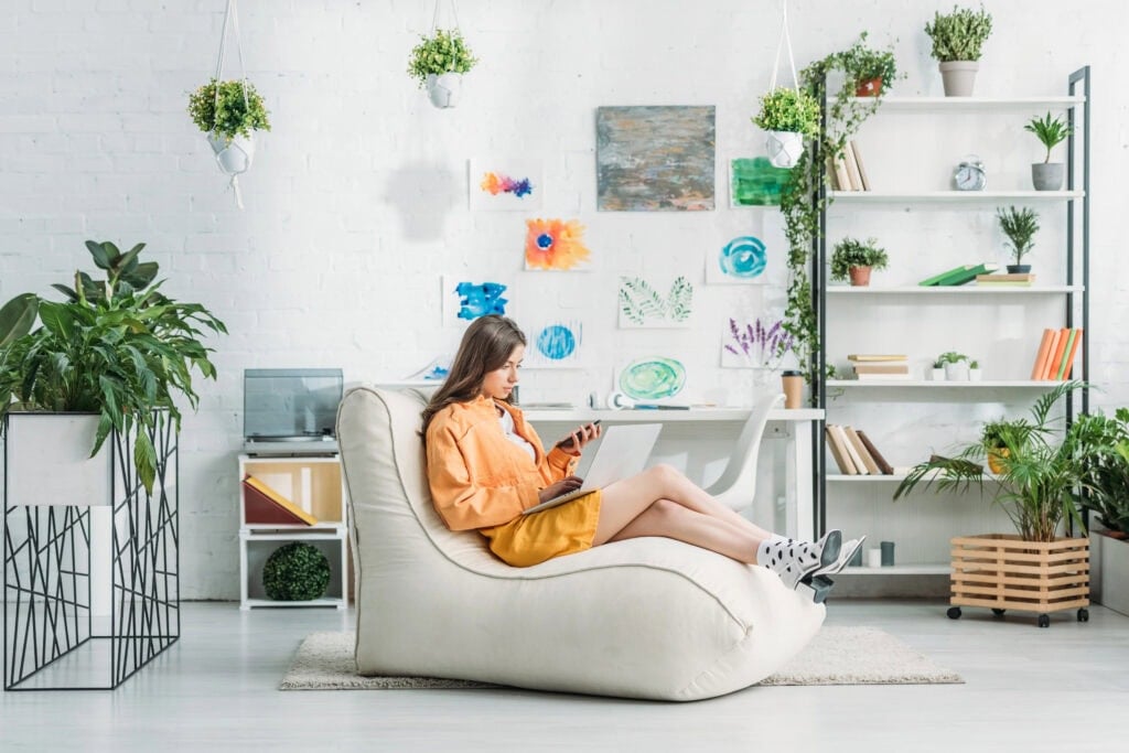 woman sitting on couch working - how to make $3,000 a month
